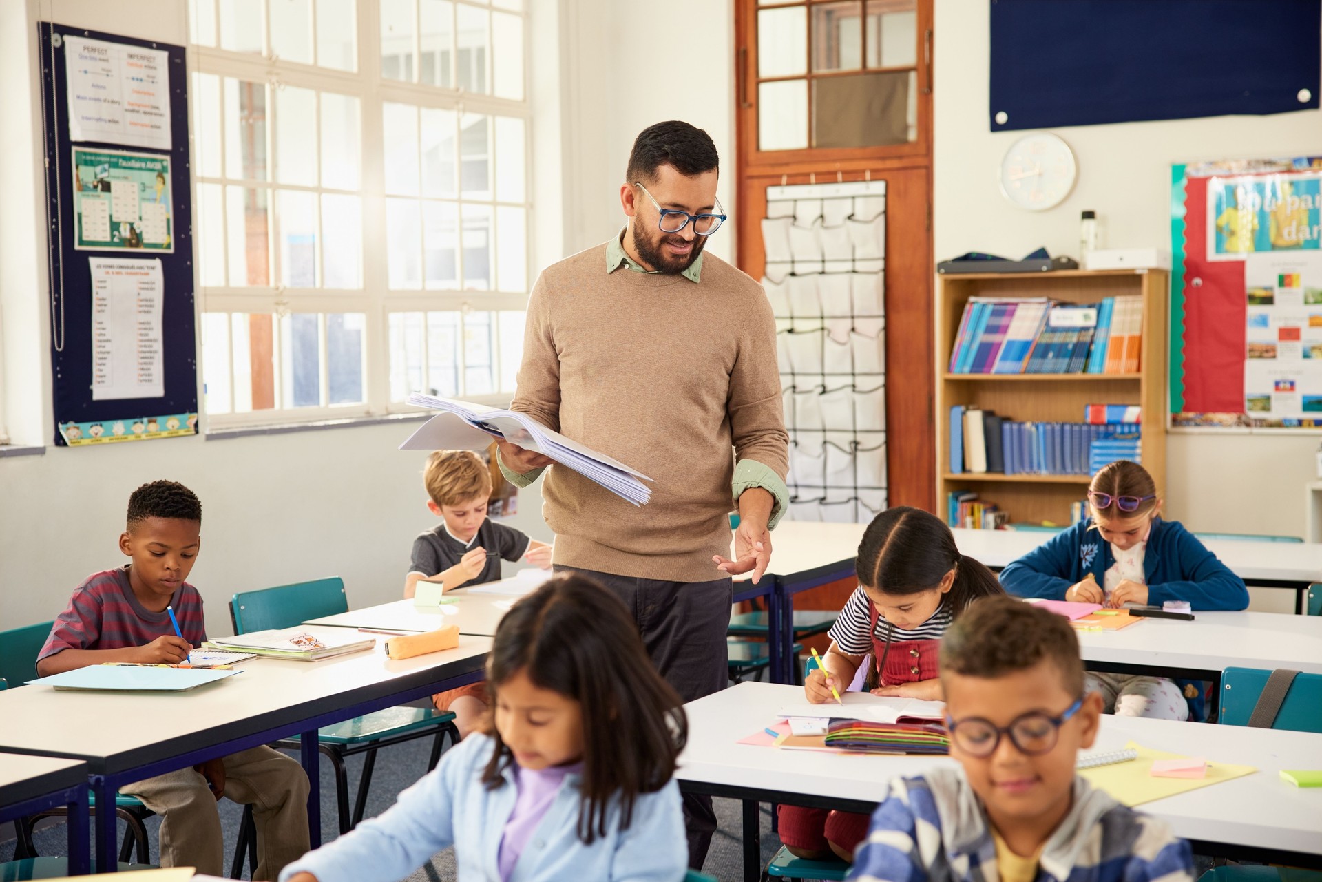 Teacher walking among school desks while dictating exercise